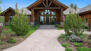 A wooden lodge with a large entrance, stone foundation, and a flag.