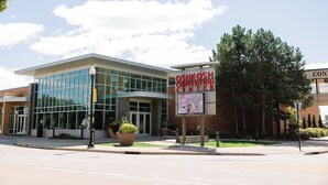 A modern building with a glass facade and a sign reading "Oshkosh Convention Center".