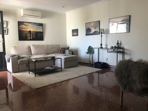 Relax in this stylish living room with a sofa, armchair, and floor-to-ceiling mirror.