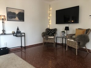 Relax in a cozy living room with a flat-screen TV, comfortable seating area, and string of lights.
