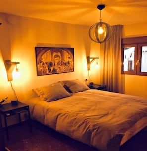 Relax in a comfortable bedroom with a large bed and a wall-mounted painting.