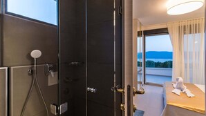 A hotel room with a shower, a bed with a view, and a balcony. - Luxury Villa Stiletta with Pool (Krk)