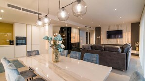 A modern kitchen with built-in appliances, a dining area with a marble table, and a living room with a sofa and TV. - Luxury Villa Stiletta with Pool (Krk)