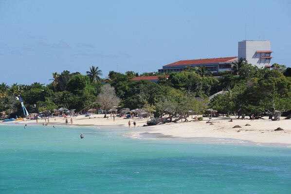 On the beach, white sand, sun-loungers, beach umbrellas
