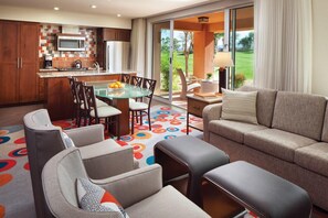 Relax in a stylish living space with a central dining table, comfortable seating, and a kitchen with modern appliances.