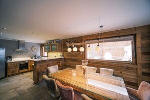 A modern kitchen with wooden cabinetry, a central island, and pendant lighting.