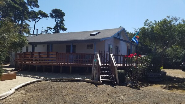 A building with a sloped roof, a wooden deck, and a flag.