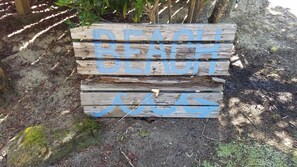 A wooden sign with the words "BEACH" and "RENTAL" painted in blue.