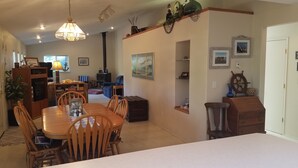 Un comedor con mesa y sillas de madera, una araña y una chimenea.