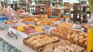 A buffet with various food items and a beverage station. - Makkai Resort Bombinhas (Bombinhas)