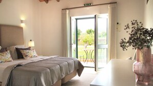 A bedroom with a bed, bedside table, and a vase of flowers. - Quinta da Luz - A Luxury Boutique B&B (Silves)