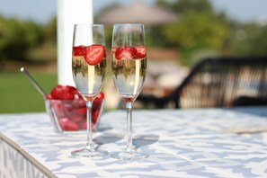 Dos copas de champán con fresas sobre una mesa con mantel estampado.