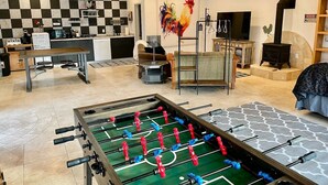 A spacious living area with a foosball table, a television, and a fireplace. - The Funky Chicken - Hot Tub - BBQ - Sleeps 4 (Ahwahnee)