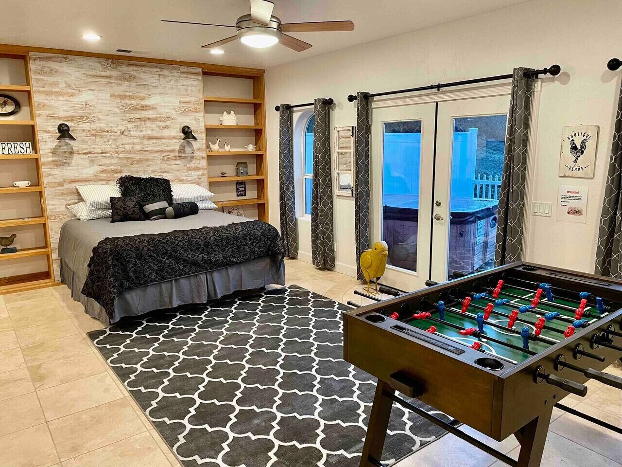 Un dormitorio con cama, mesa de fútbol y vista al exterior.
