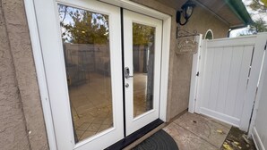 A white door with a glass panel, a welcome sign, and a black doormat. - The Funky Chicken - Hot Tub - BBQ - Sleeps 4 (Ahwahnee)