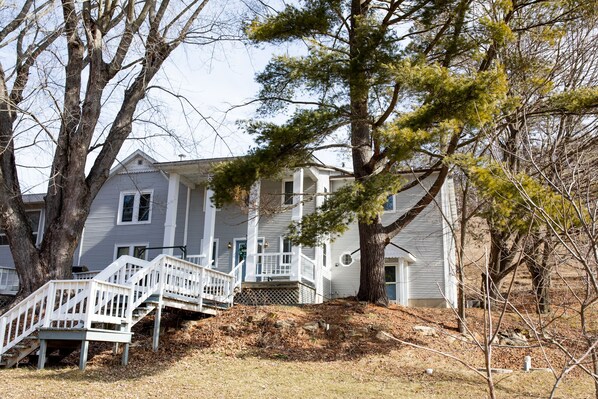 A two-story house with a front porch and a staircase leading to the entrance. - Spacious & secluded grand home near Kickapoo River, Bike Trails, & ATV routes (Norwalk)