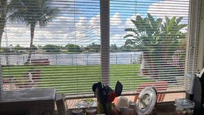 Una cocina con vistas a una zona verde y un cuerpo de agua a través de amplios ventanales.