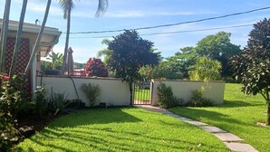 Un césped cuidado con un sendero que lleva a una entrada con portón.