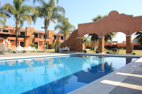 Alberca al aire libre y camastros