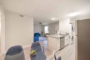Een modern appartement met keuken, eethoek en woonkamer.