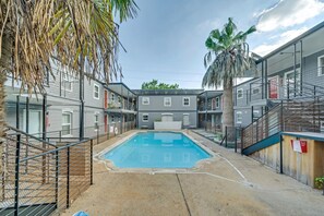 Guests can enjoy a refreshing swim in the central pool surrounded by lush vegetation.