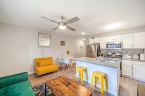 A modern kitchen with white cabinets, a stainless steel refrigerator, and a built-in oven.