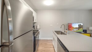 Une cuisine moderne dotée d’appareils électroménagers en acier inoxydable, d’un four encastré et d’un grand îlot central avec un évier.