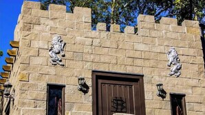 Un bâtiment en pierre doté d’une porte centrale et de deux sculptures de lions de chaque côté.
