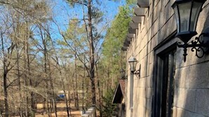 Un chemin de pierre mène à un bâtiment doté d’un mur en pierre et d’un lampadaire.
