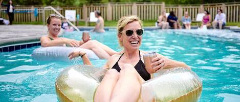 Una piscina con persone che utilizzano cerchi gonfiabili.