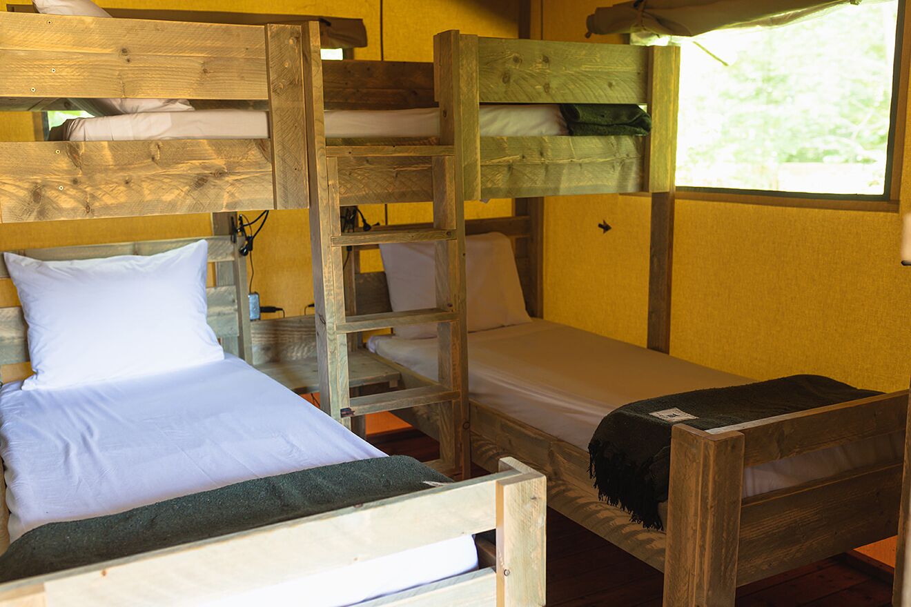A bunk bed room with wooden frames and white bedding.