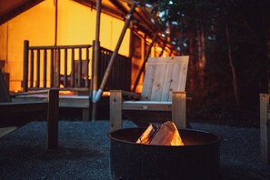 Leirintäalueella on nuotiopaikka, jossa on polttopuita, puisia tuoleja ja puinen terassi.