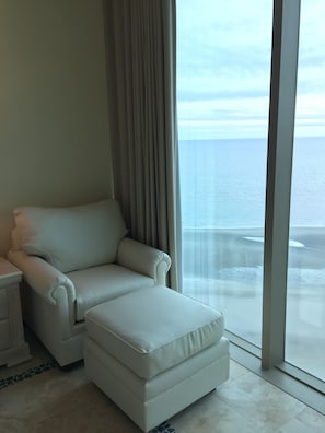 Une chambre moderne dotée d’une grande fenêtre donnant sur l’océan.