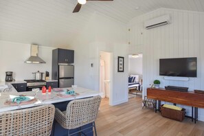 A modern kitchen with a stove, refrigerator, and dark cabinets. - Newly Renovated Cottage on Town Cove! (Eastham)