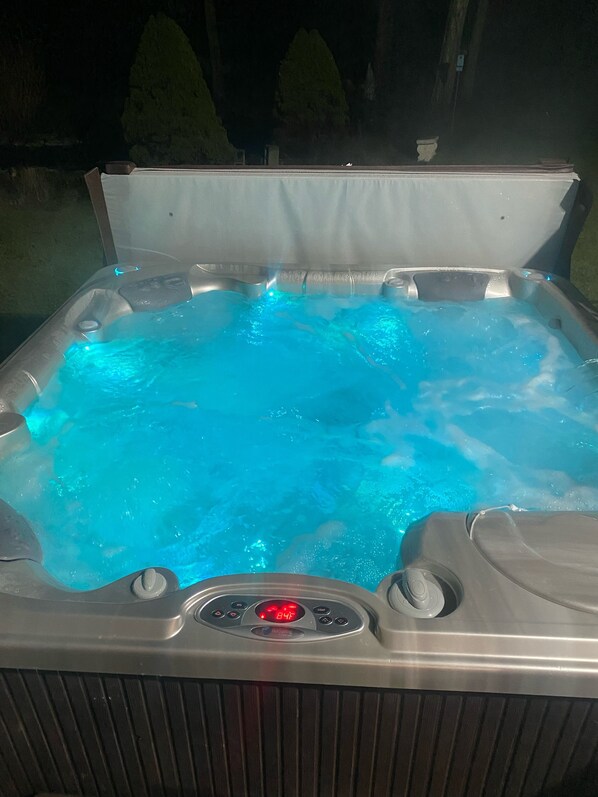 A hot tub with a digital control panel displaying the temperature.