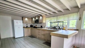 A kitchen with a central island, wooden cabinets, a built-in microwave, and a window with blinds. - Grand Chalet,  Private Pool, AC, River Access, Pool Table BBQ WIFI Parking (Rio Grande)