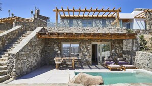 A stone building with a pool, wooden pergola, and outdoor seating. - Due Mari Mykonos (Mykonos)
