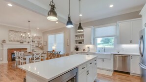 A modern kitchen with white cabinetry, a large island, and pendant lighting. - Superstar Country Retreat - Historic Franklin Home (Franklin)