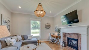 A living room with a sofa, coffee table, and fireplace. - Superstar Country Retreat - Historic Franklin Home (Franklin)
