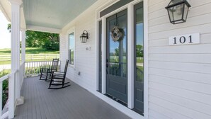 A porch with a white railing, black rocking chairs, and a door with a wreath. The number 101 is displayed on the wall. - Superstar Country Retreat - Historic Franklin Home (Franklin)