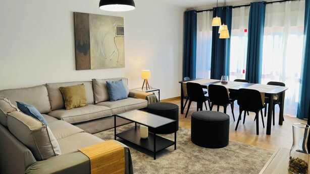 Un salon moderne avec un canapé, une table basse et un coin repas.