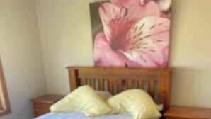 A bedroom with a wooden bed, two nightstands, and a nightstand with drawers. - Hidden Oasis on Piper.  Park your car and walk to everything (Yarrawonga)