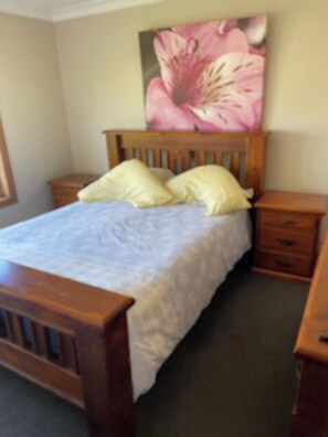 Cozy retreat with a single bed, nightstand, and floral headboard.