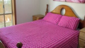 A bedroom with a bed, wooden headboard, and a window. - Hidden Oasis on Piper.  Park your car and walk to everything (Yarrawonga)