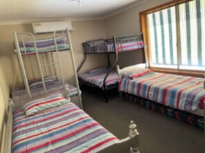 Cozy dormitory room with bunk beds and a window for natural ventilation.