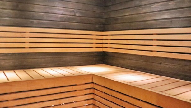 Una sauna amb bancs de fusta i parets de llistons.