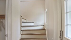 Una escala amb graons de fusta i parets blanques.