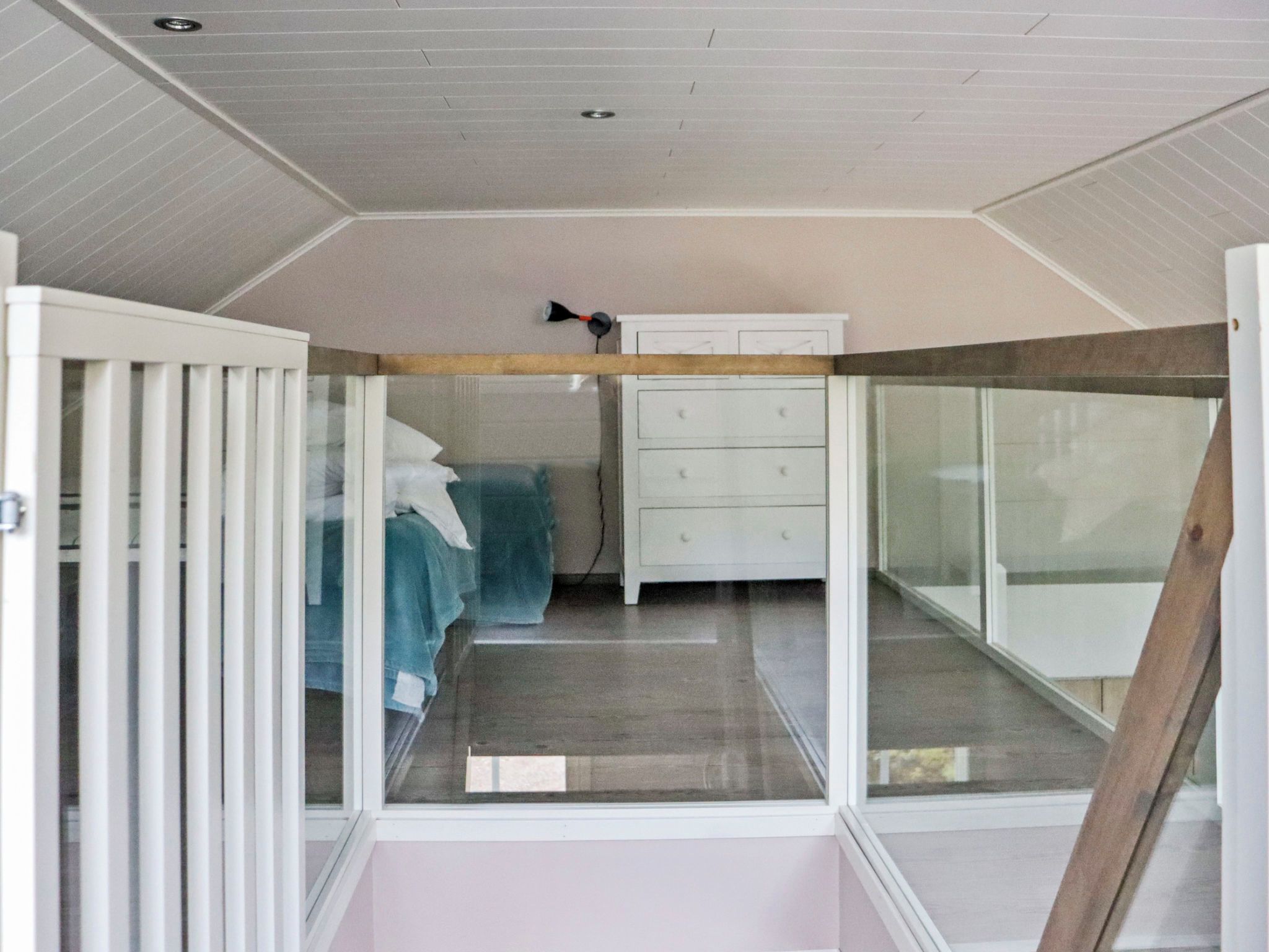 A bedroom with a bed, a dresser, and a window.