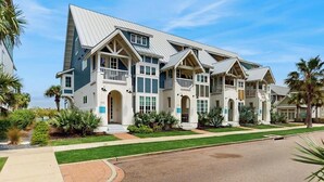 A multi-story hotel with a symmetrical facade, multiple balconies, and a well-maintained lawn. - Luxury townhome with games, high-speed WiFi, pool access, AC & beach service (Port Aransas)