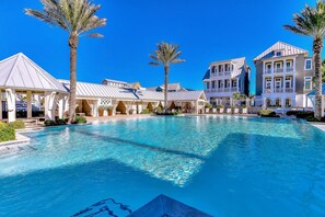 A swimming pool surrounded by buildings with a clear blue sky. - Townhouse + loft with private balcony, heated pool, gym, beach access & W/D (Port Aransas)